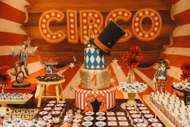 Circus-themed first birthday cake with dessert table and party decorations